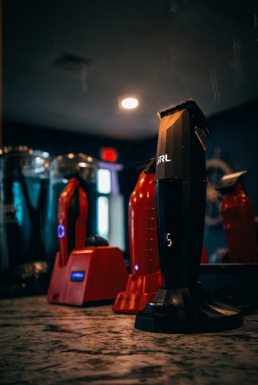 JRL clipper on marble station inside Coastal — moody navy interior with warm ambient light